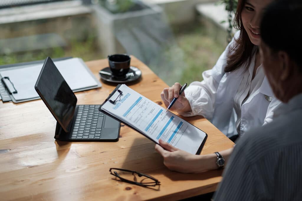 Board-certified plastic surgeon discussing the cost of lower and upper eyelid surgery with a patient, a surgical procedure designed to remove excess skin in the eyes.