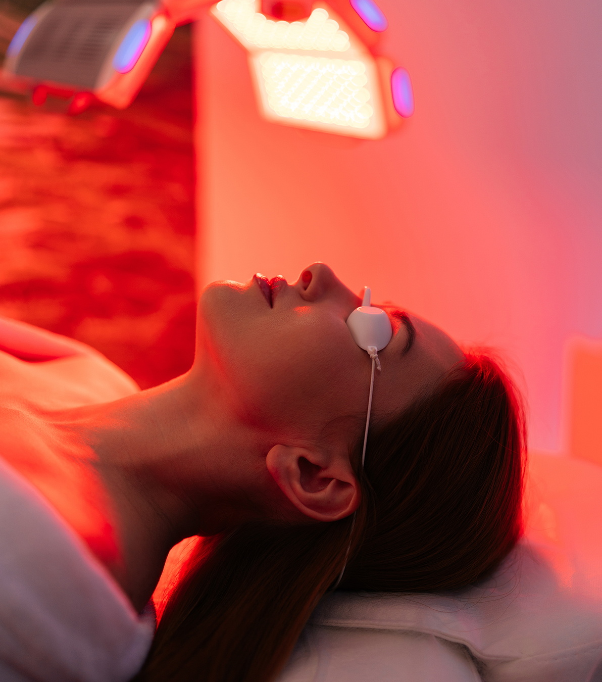 Woman receiving red light therapy facial treatment using LightStim by Elipsa to boost collagen and skin rejuvenation.