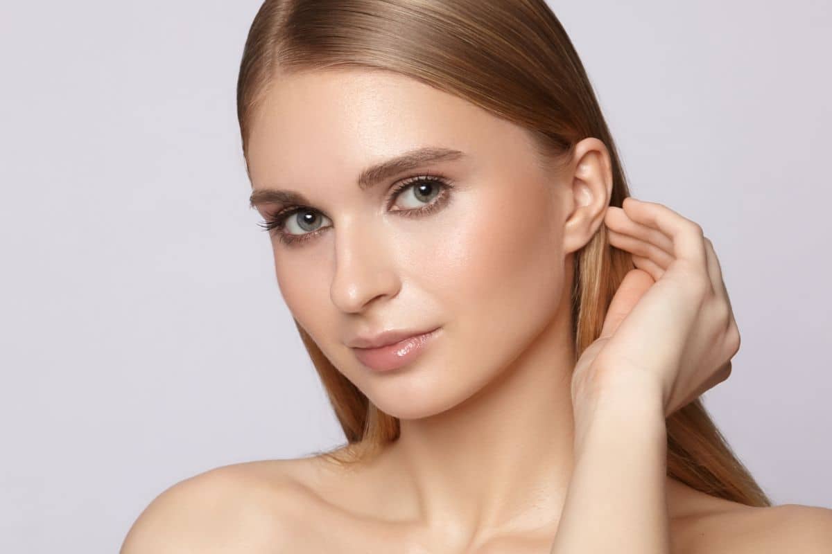 Portrait of woman showcasing smooth, symmetrical nose, illustrating outcomes of liquid and surgical rhinoplasty procedures