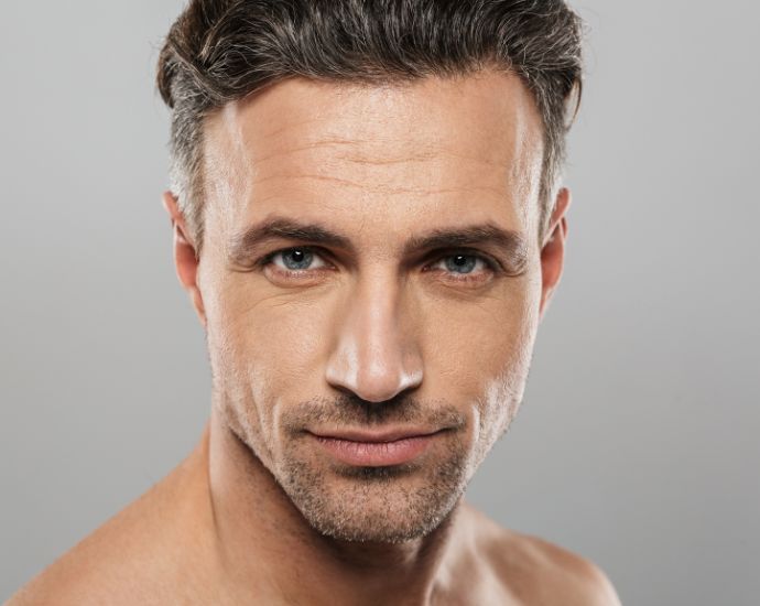 Confident middle-aged man with defined facial features, ideal candidate for subtle male dermal filler treatments.