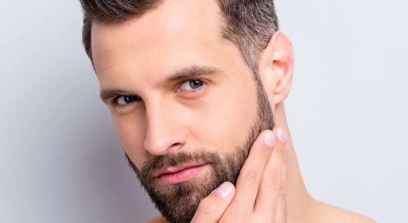 Man touching temple area after dermal filler treatment to restore volume and improve overall facial symmetry.
