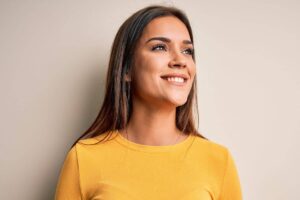 Woman smiling confidently after closed rhinoplasty with no visible scars and natural-looking nose results.