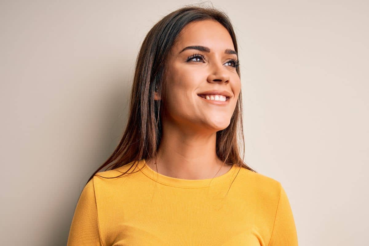 Woman smiling confidently after closed rhinoplasty with no visible scars and natural-looking nose results.