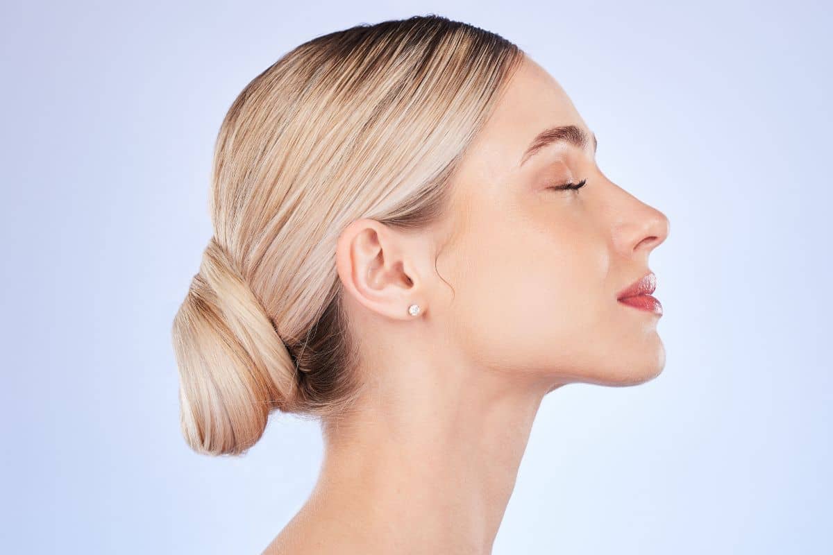 Side view of woman with smooth skin and balanced nose, reflecting rhinoplasty results and cost considerations.