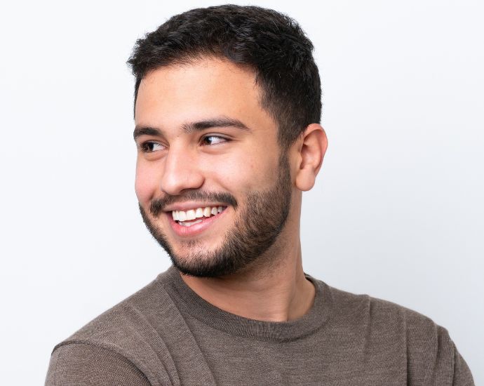 Smiling Latin man with well-defined nose highlighting ethnic diversity in rhinoplasty for Latin American features.