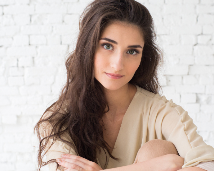 Young Persian woman with long dark hair and soft makeup, symbolizing cultural acceptance of rhinoplasty in Persian communities.