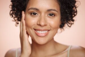 Smiling woman with smooth, radiant skin showing results of UltraClear laser scar treatment.