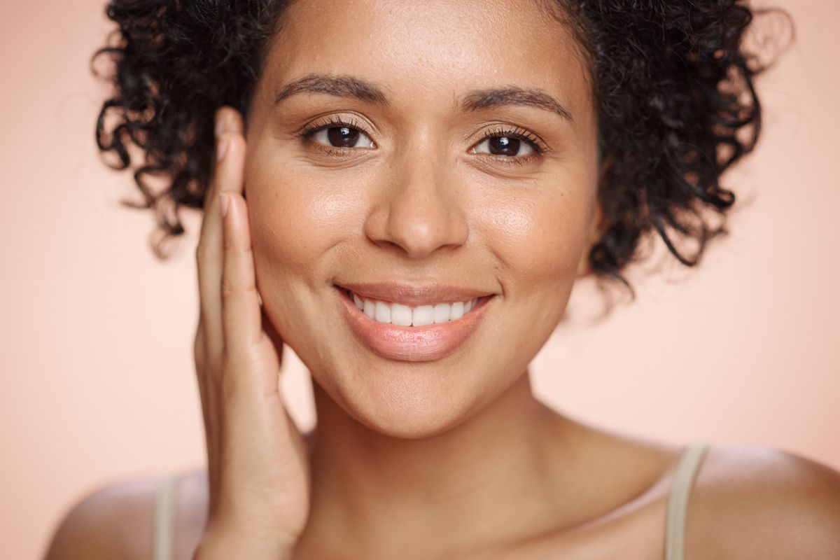 Smiling woman with smooth, radiant skin showing results of UltraClear laser scar treatment.