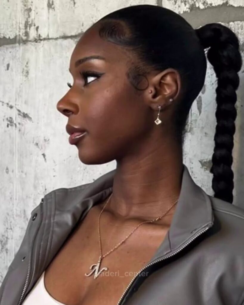 Side profile of Black woman with defined nose and sleek ponytail, reflecting expert African American rhinoplasty results.