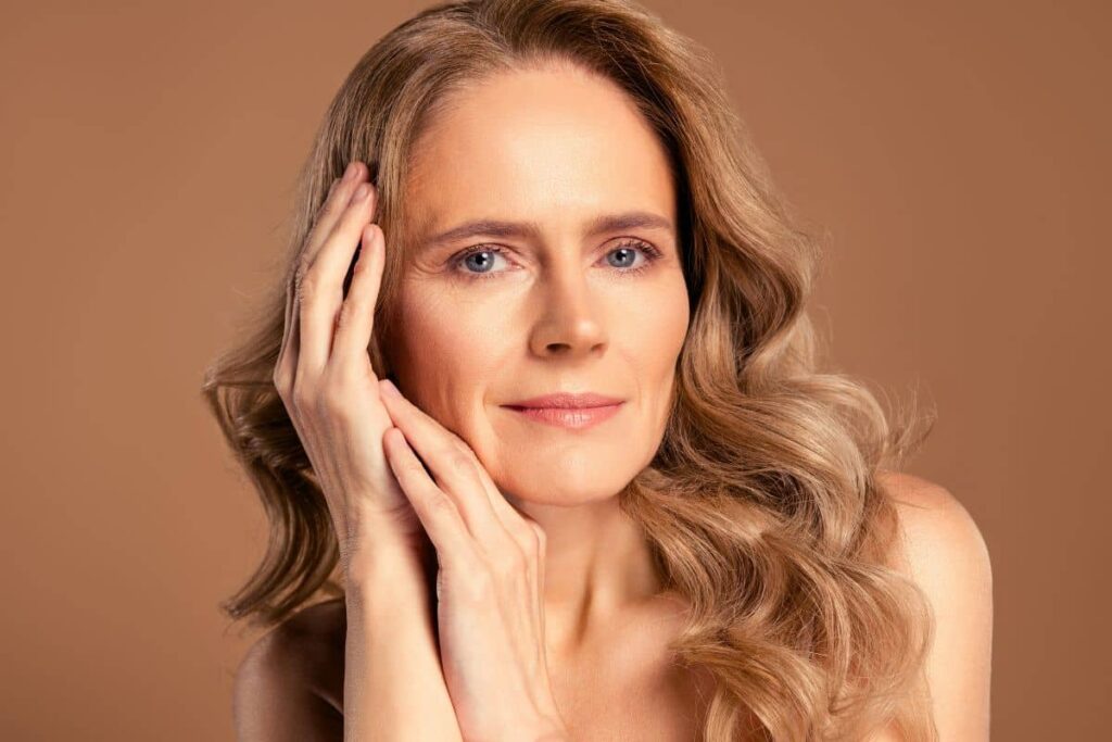 Close-up of mature woman smiling with smooth skin, showcasing long-lasting rhinoplasty results and natural beauty.