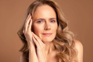 Close-up of mature woman smiling with smooth skin, showcasing long-lasting rhinoplasty results and natural beauty.