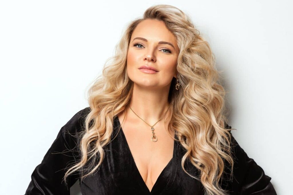 Confident woman with voluminous blonde hair and sculpted features representing the elite Mar-a-Lago Face trend.