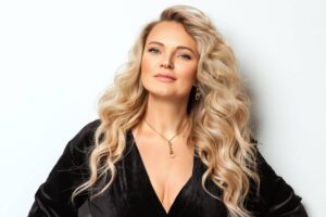 Confident woman with voluminous blonde hair and sculpted features representing the elite Mar-a-Lago Face trend.