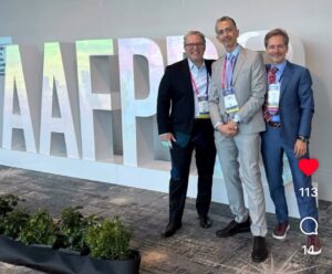 Three facial plastic surgeons posing at the AAFPRS meeting, representing international collaboration in advanced surgical care.