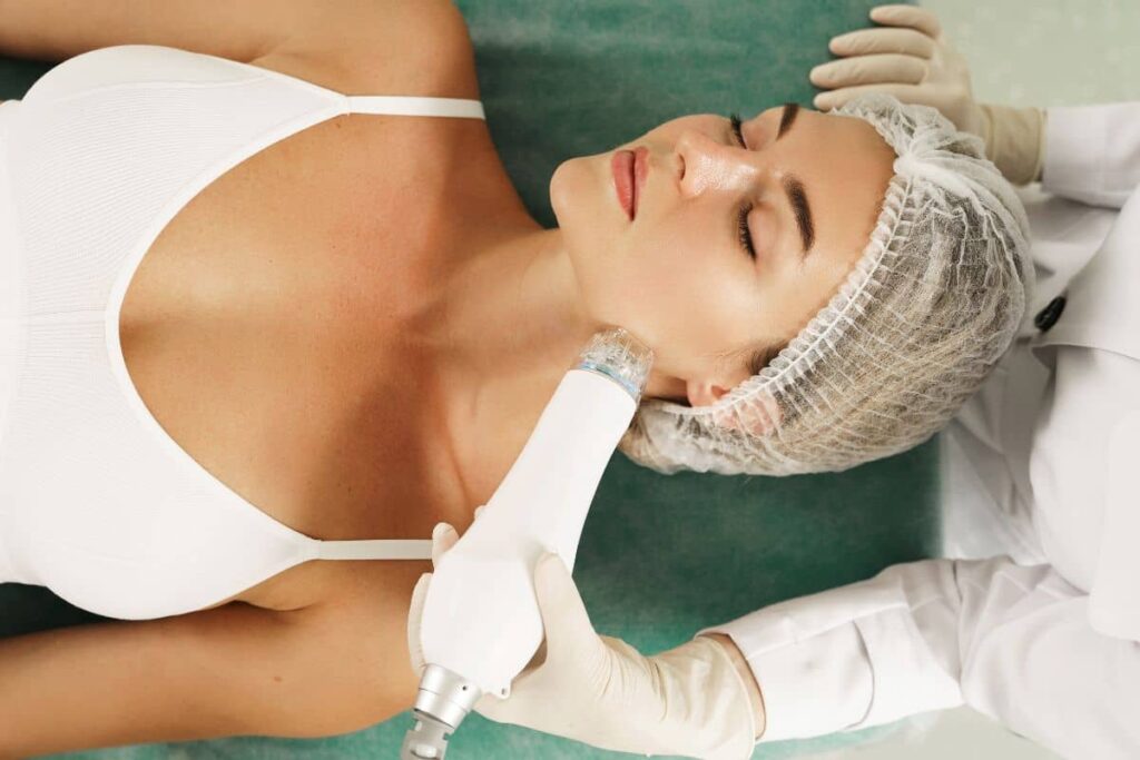 Woman receiving non-invasive treatments with Morpheus8 device to tighten and contour lower face and jawline