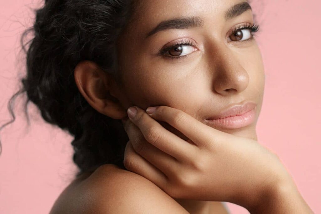 Woman with clear, radiant skin looking confident after personalized hyperpigmentation treatment.