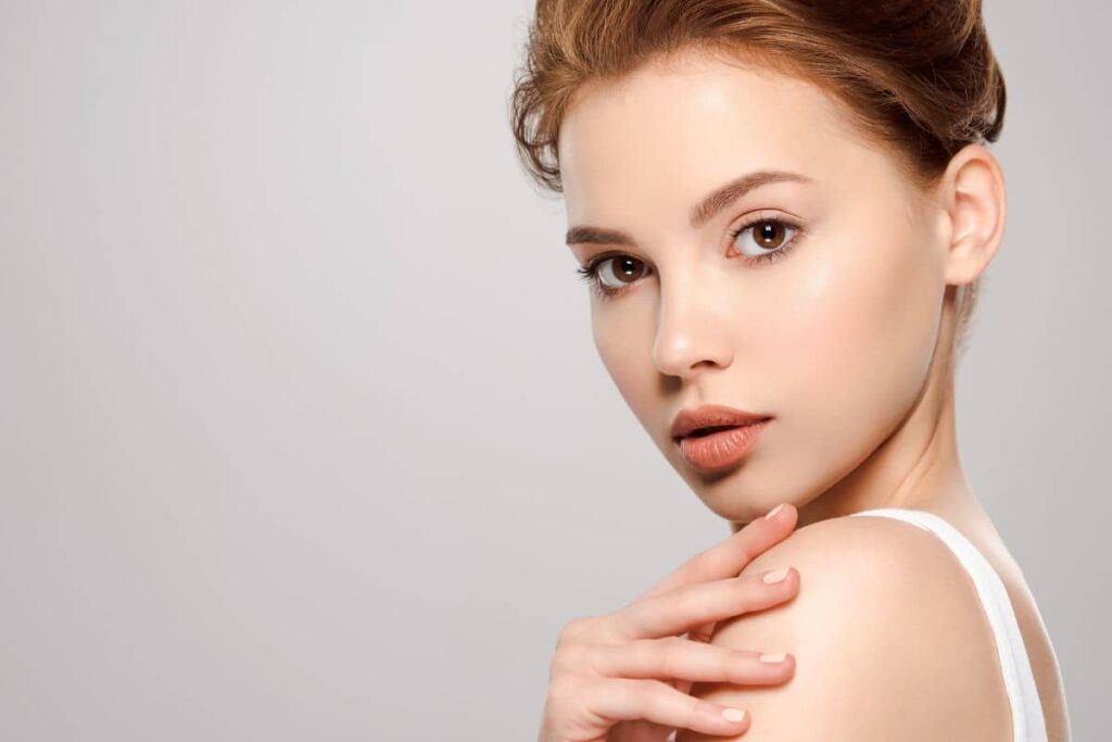 Woman with radiant, natural-looking skin showcasing 2025 aesthetic trend favoring subtle and individualized beauty.