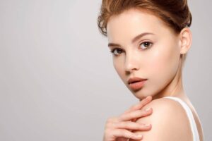 Woman with radiant, natural-looking skin showcasing 2025 aesthetic trend favoring subtle and individualized beauty.