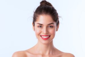 Smiling woman with smooth skin and natural facial contours representing modern facelift results for younger patients