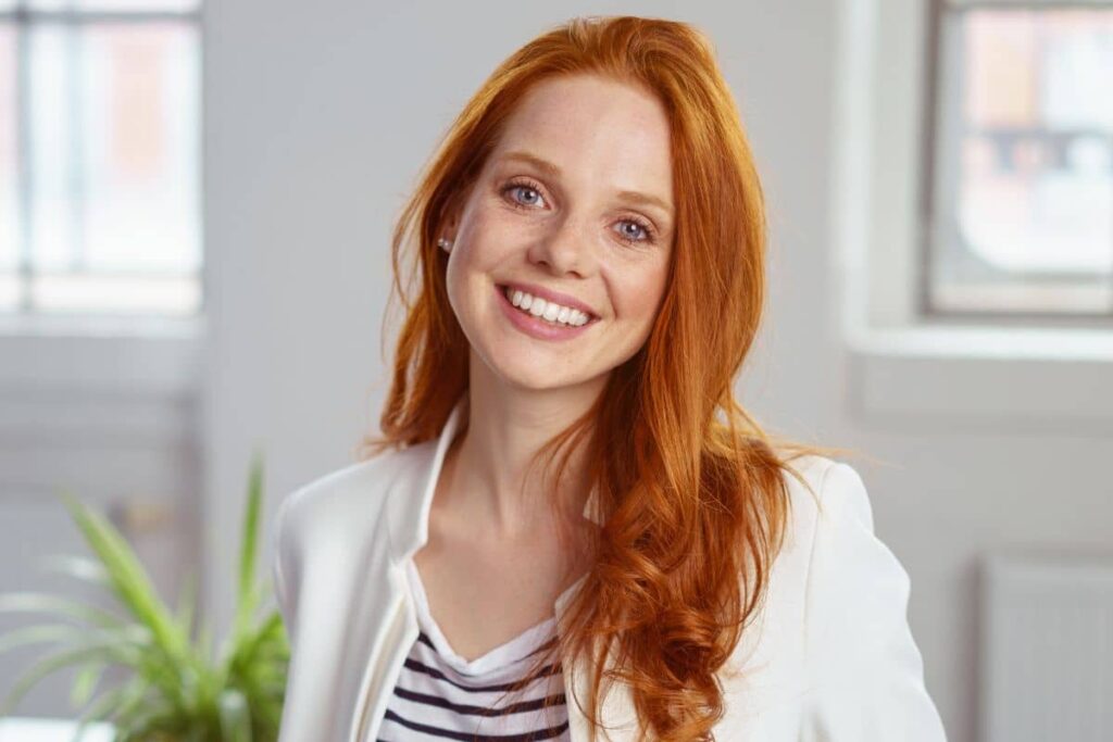 Smiling woman with natural, youthful features representing the trend of early facelifts for long-lasting results and proactive aging.