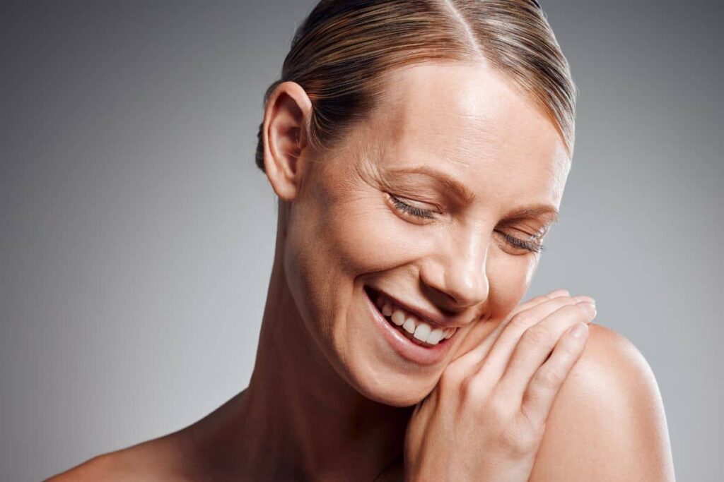 Smiling woman with smooth, firm skin showing an effective personalized skin tightening treatment outcome.
