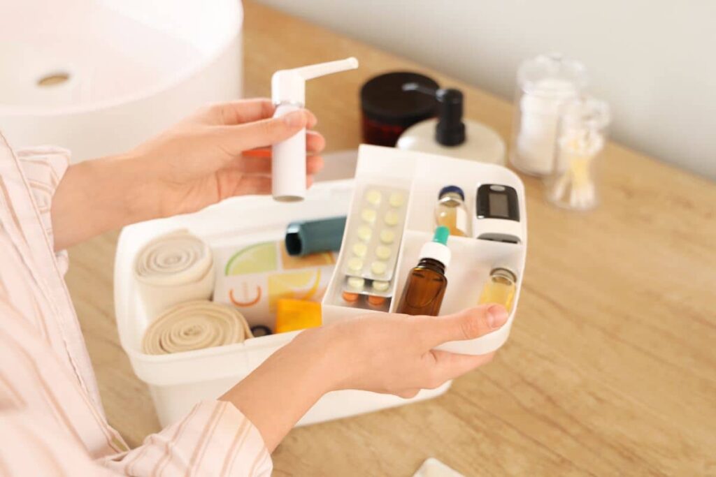 Close-up of hands holding a medical supply kit with medications, bandages, and recovery essentials for brow lift preparation.