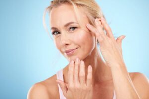 Woman gently touching face, illustrating facial rejuvenation and skin tightening after deep plane facelift procedure