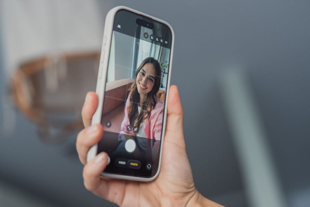 Smartphone selfie showing woman on screen highlighting zoom effect and increased awareness of eye appearance and aging signs