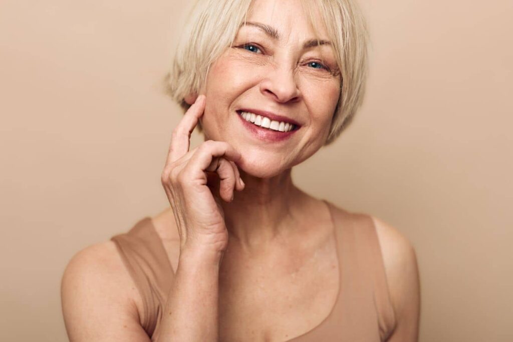Smiling older woman illustrating facelift longevity, healthy aging, skin elasticity, and natural facial rejuvenation results
