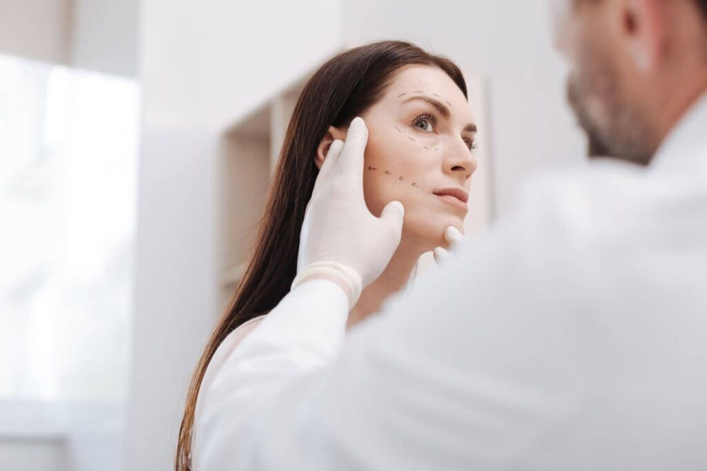 Cosmetic surgeon reviewing facial aging patterns for customized facelift and natural rejuvenation planning