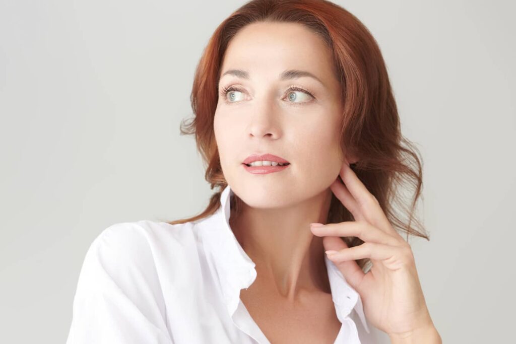 Woman with youthful appearance highlighting early deep plane facelift trend and natural facial rejuvenation results.
