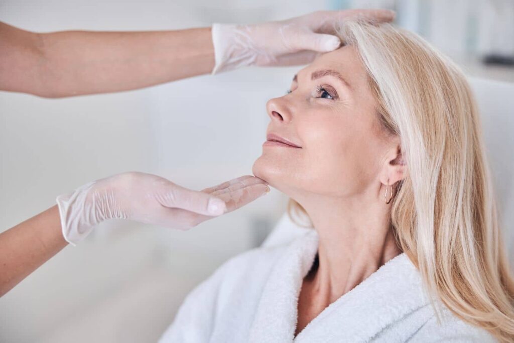 Surgeon evaluating a facelift patient before treatment, highlighting how surgical technique influences recovery and results.