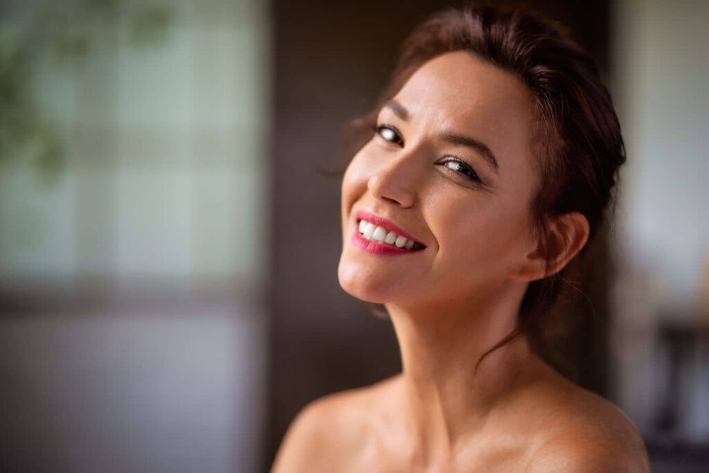 Smiling woman in her 40s representing preventative facial rejuvenation and natural aging.