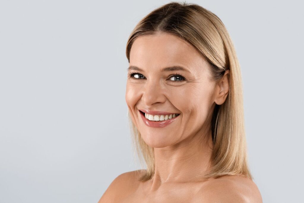Smiling mature woman representing natural facial rejuvenation focused on preserving identity, balance, and authentic aging.