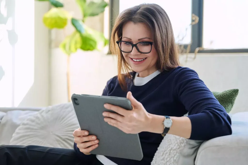 Woman reviewing facelift results on a tablet.