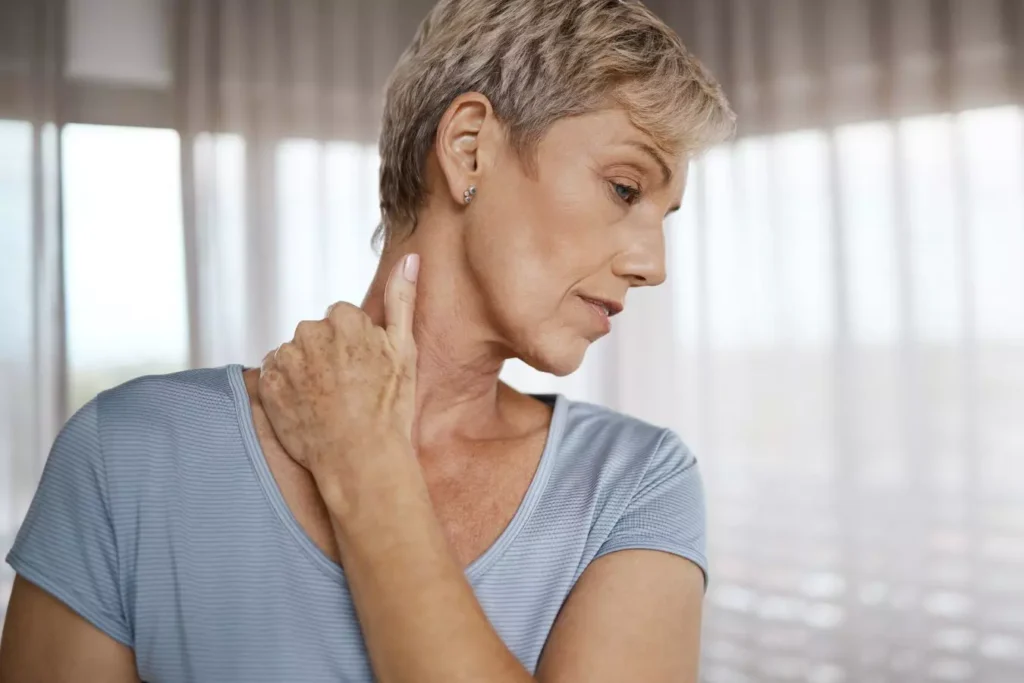 Woman examining her neck and jawline profile.