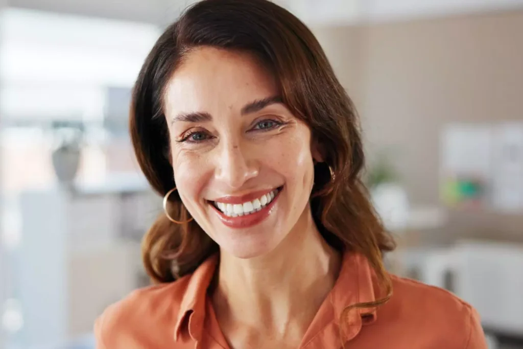 Smiling woman with natural, youthful facial features.