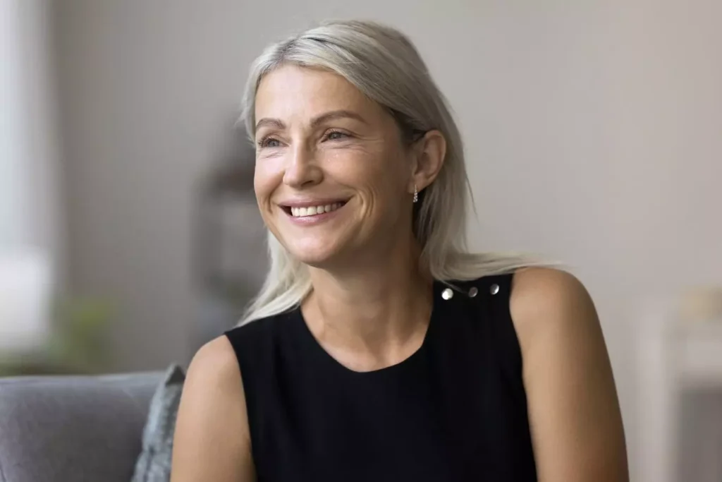 Smiling mature woman representing facelift candidacy and facial aging.