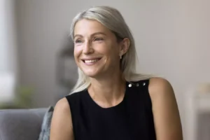 Smiling mature woman representing facelift candidacy and facial aging.