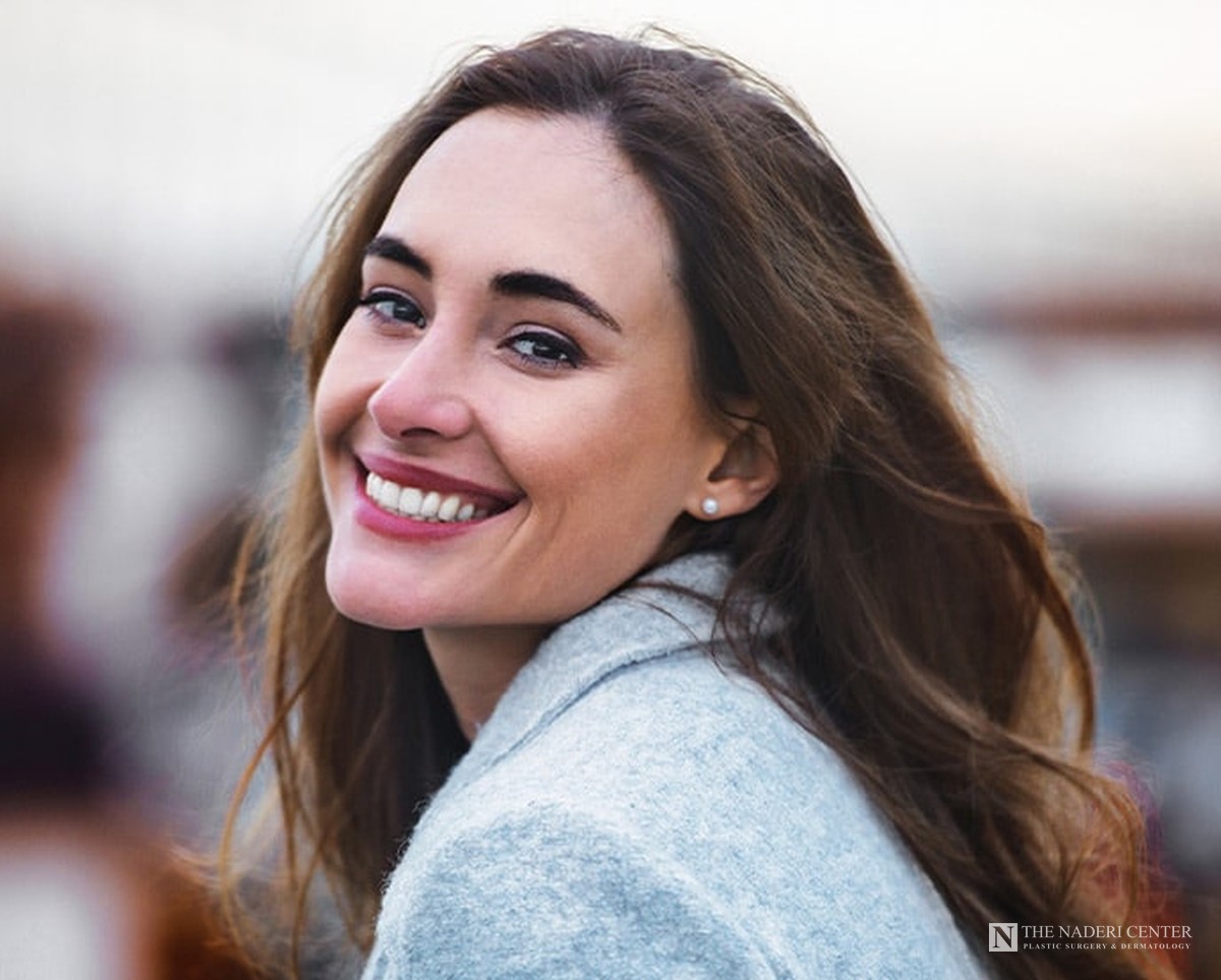 Smiling woman with smooth, clear skin, representing acne scar laser treatment at The Naderi Center in Reston and Chevy Chase