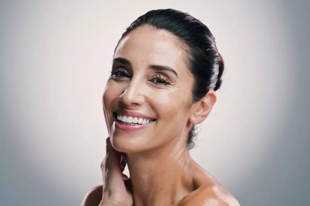 Smiling woman with youthful facial contours and natural-looking facelift results.