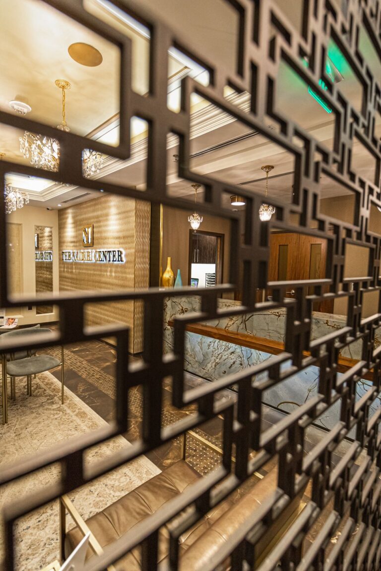 Reception and logo wall seen through a lattice screen at The Naderi Center in Reston, Virginia